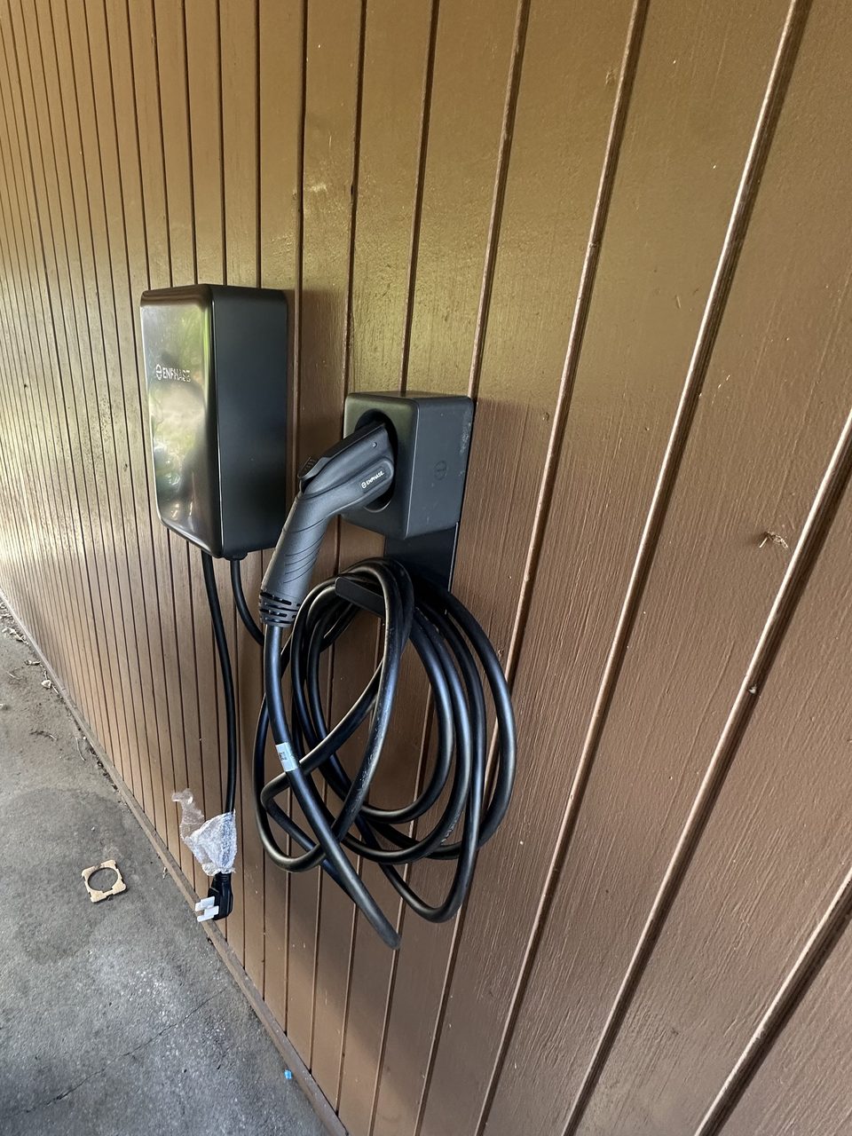 Enphase Level 2 EV charger and holster mounted on a carport wall